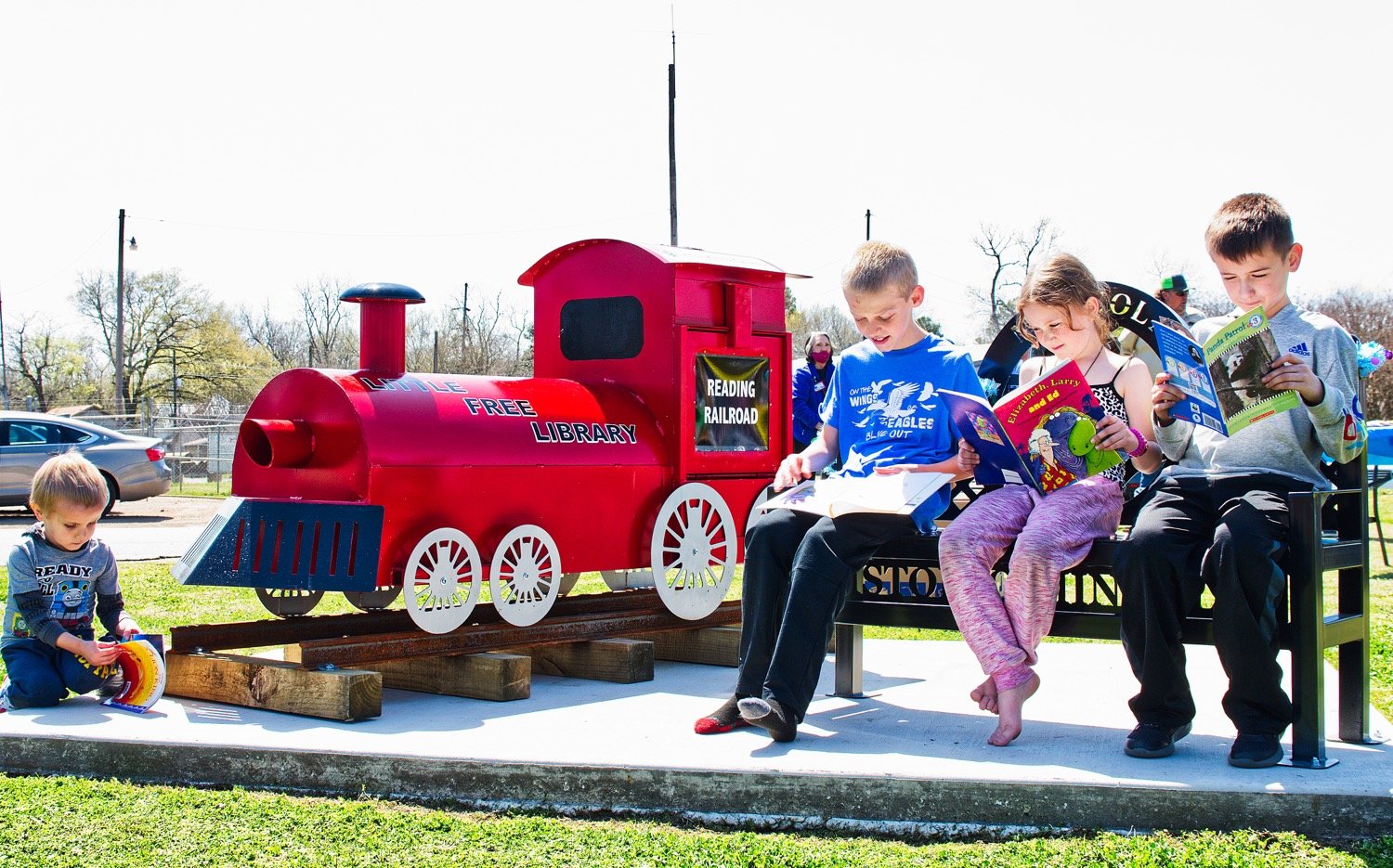 Children enjoy books at the new little free library, dubbed the Reading Railroad, at Iron Horse Square in Mineola. The library was dedicated Saturday.